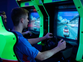 Jeune homme en train de faire une course dans un jeu d'arcade.