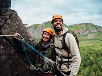 Couple heureux sur la falaise d'un parcours de via ferrata au Saguenay-Lac-Saint-Jean.