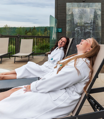 Deux femmes sur des chaises d'extérieur aux installations de spa du Ax Hôtel.