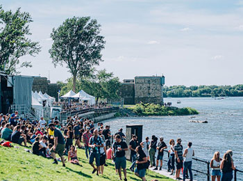 Foule assemblée au bord de l'eau lors d'un festival.