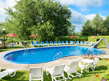 Piscine creusée extérieure entourée de chaises longues.