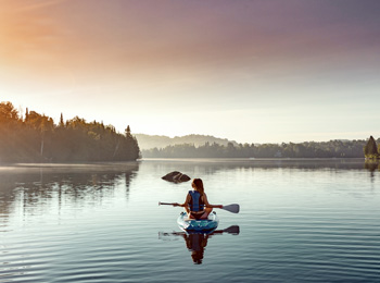 Femme sur le lac en paddleboard à Estérel Resort.