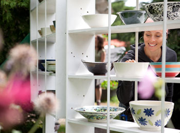 Femme souriante en train de regarder les pots en céramique.