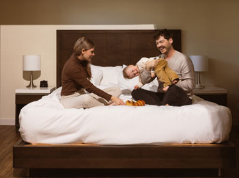 Deux jeunes parents et un enfant sur un lit.