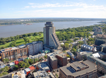 L'Hôtel le Concorde à Québec vu de haut, avec les plaines d'Abraham et le fleuve en arrière.