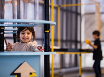 Petite fille qui s'amuse aux défis à bidouiller au Musée de l'ingéniosité Bombardier.