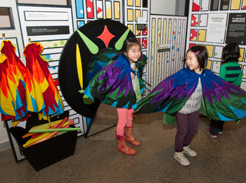 3 enfants en costume visitant l'exposition du musée.