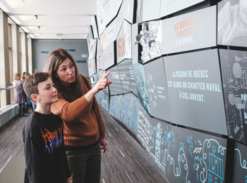 Une femme et son fils en train d'observer une exposition.