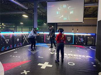 Trois personnes en train de s’affronter dans une arène de réalité virtuelle.