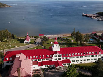 Vue aérienne d'un hôtel au toit rouge situé au bord de l'eau.