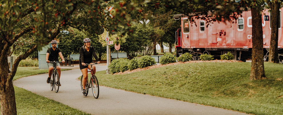 Couple à vélo sur un sentier asphalté.