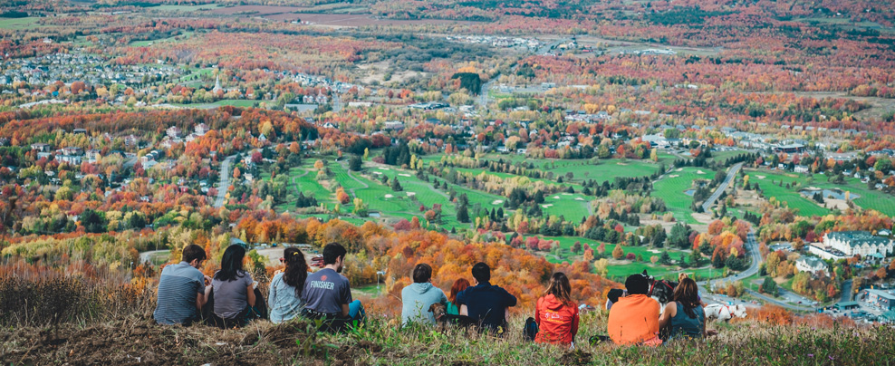 Groupe de personne assis au sommet d’une montagne en automne.